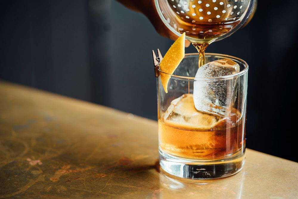 Cocktail being strained into a glass