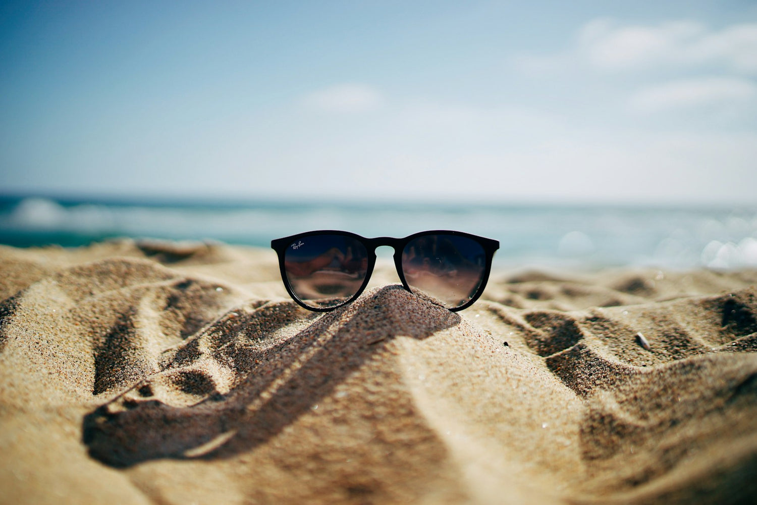 Sunglasses resting on sand