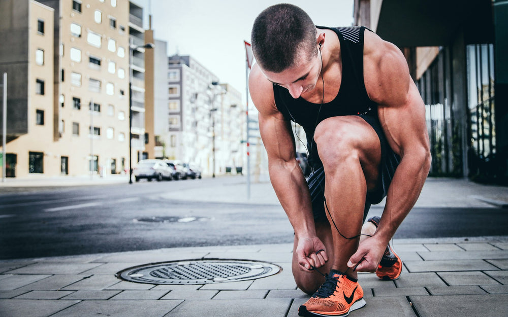 Runner tying a shoelace in the street