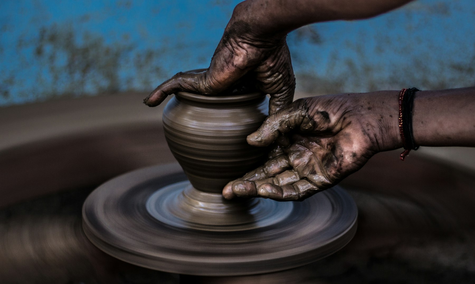 Hands throwing a pot on the wheel