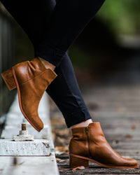 Tan leather zip ankle boots worn with slim trousers