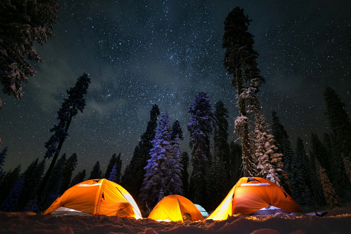 Lit tents under a starry sky