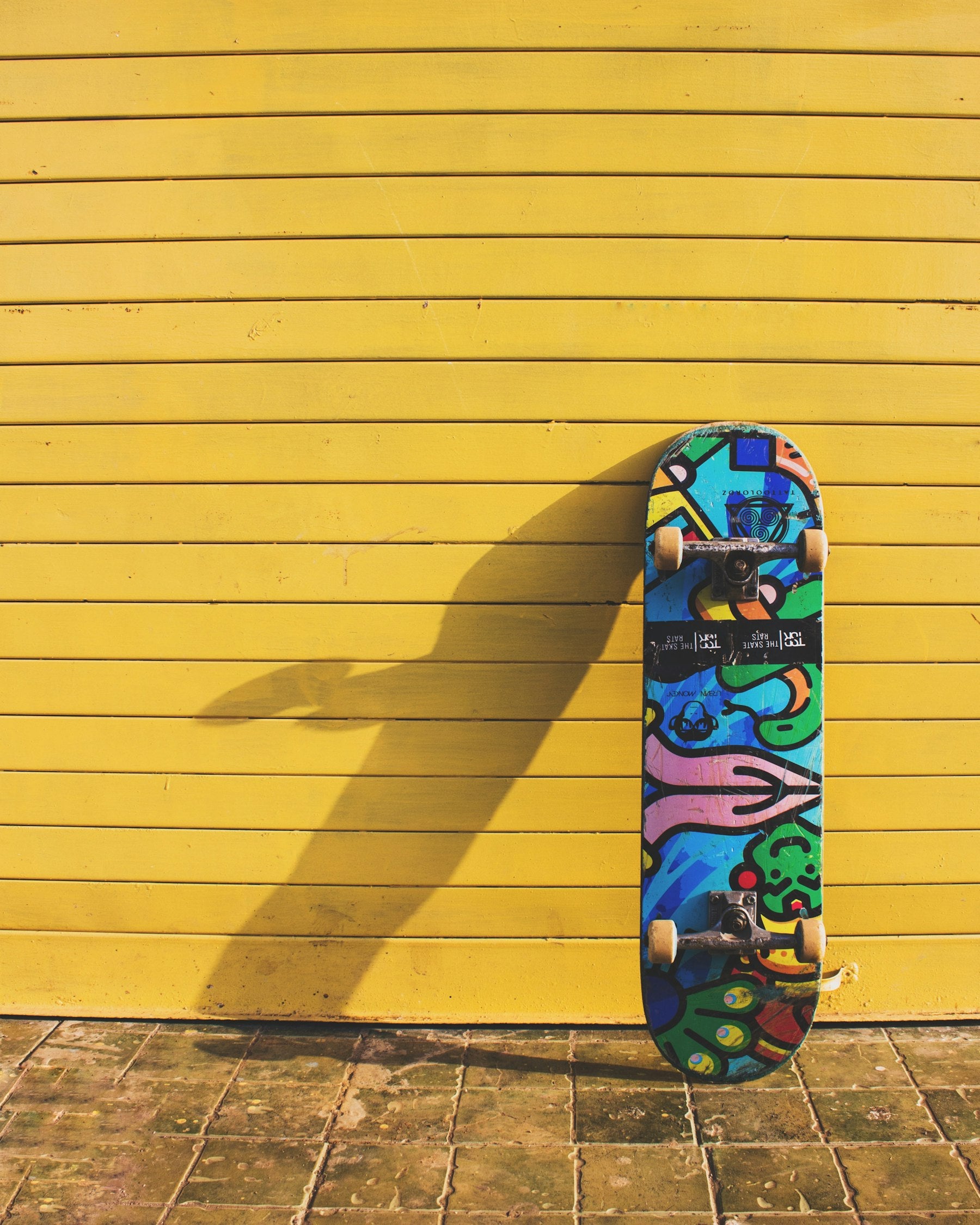 Painted skateboard on a yellow wall