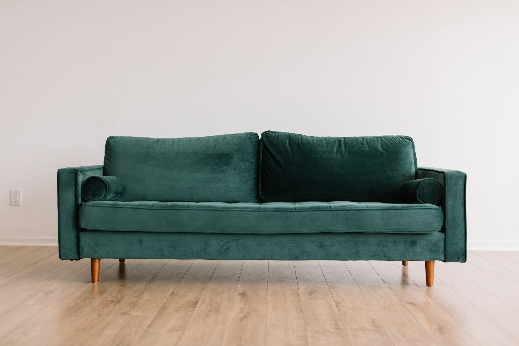 Green velvet sofa on pale floor