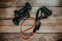Resistance bands and small dumbbells on a wooden floor