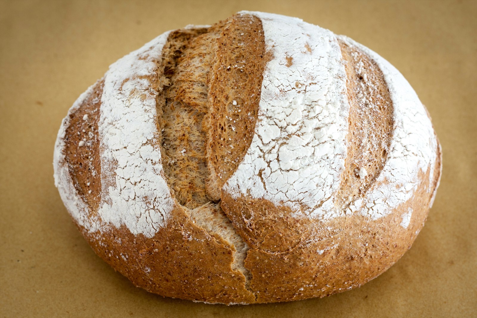 A scored sourdough boule with a floured crust