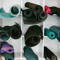 Rolled yoga mats stacked in a studio rack