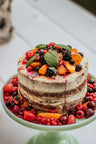 A layer cake topped with fresh berries and mint