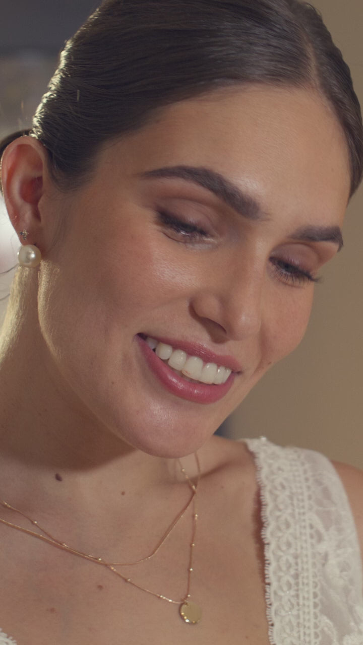 Layered fine gold necklaces worn open-collar