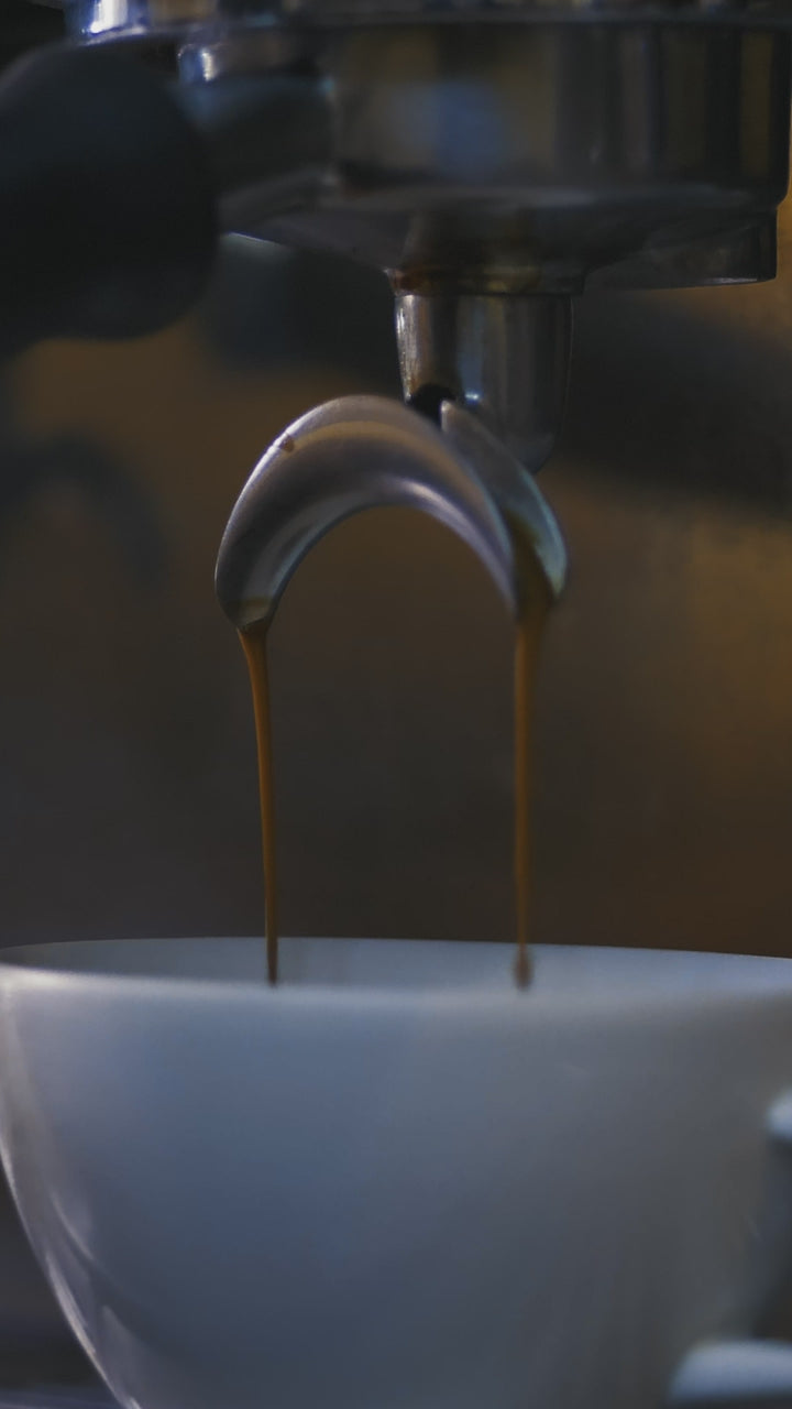 Espresso pouring from a machine into a cup