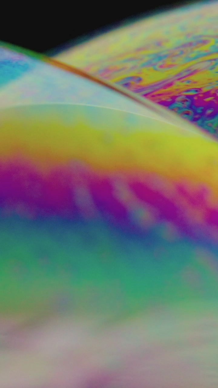 The curved surface of a soap bubble catching the light