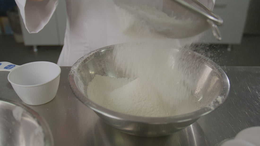 Sifting flour into a mixing bowl