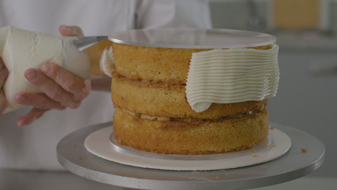 Smoothing icing around a layer cake with a palette knife